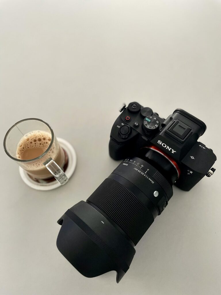 Top view of a camera and coffee on a white background in Thrissur, Kerala, India.